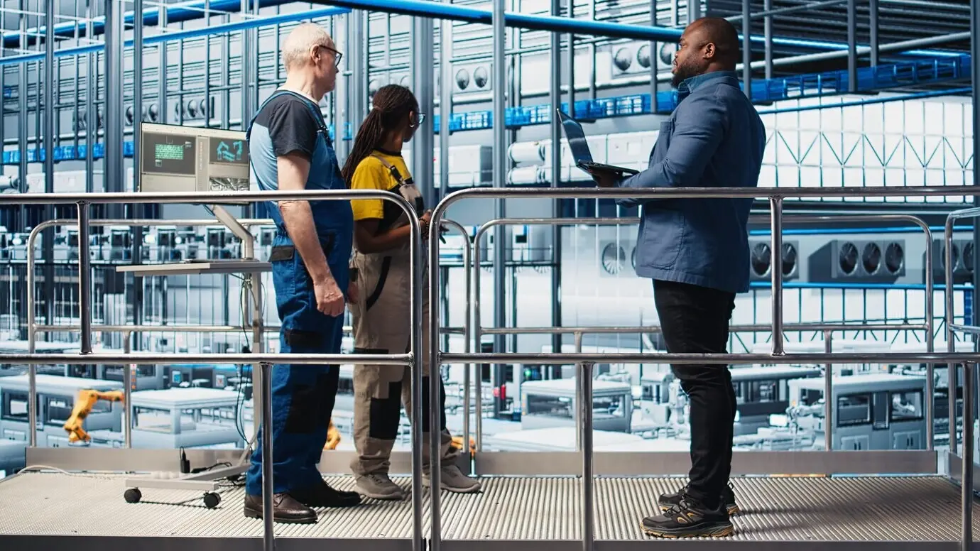 Investor besucht eine Industrie-4.0-Solarmodulfabrik und spricht mit Ingenieuren.